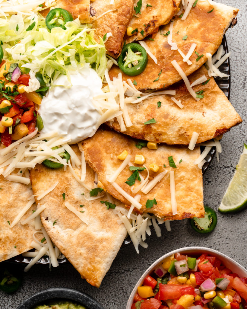 Super crispy quesadillas filled with tropical pineapple lime chicken, monterrey jack cheese, corn, black beans, and peppers