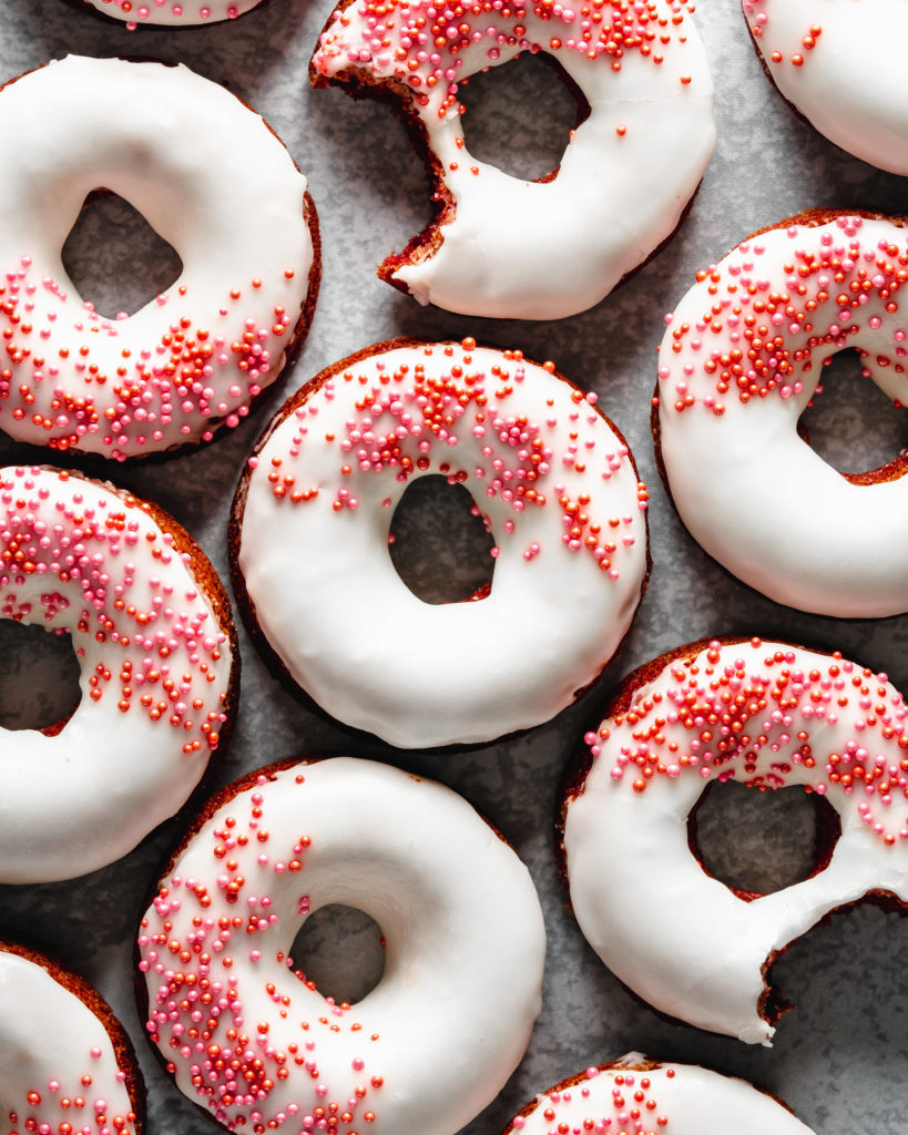Easy to make baked red velvet donuts are glazed with a cream cheese frosting