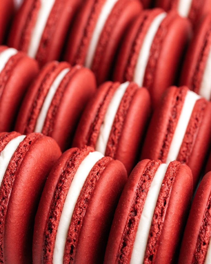 Red Velvet Macarons, filled with cream cheese frosting, lined up ready to be eaten