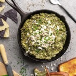 Creamy bright green spinach dip and artichoke dip, topped with feta cheese and chives and served warm
