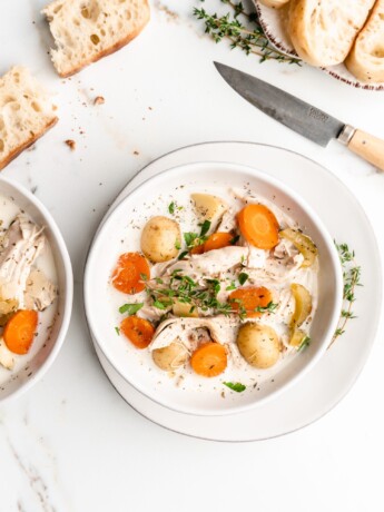 Creamy chicken soup is hot and ready to be eaten. Full of chicken, celery, carrots, potatoes, cream, bacon, and thyme, this soup is delicious!