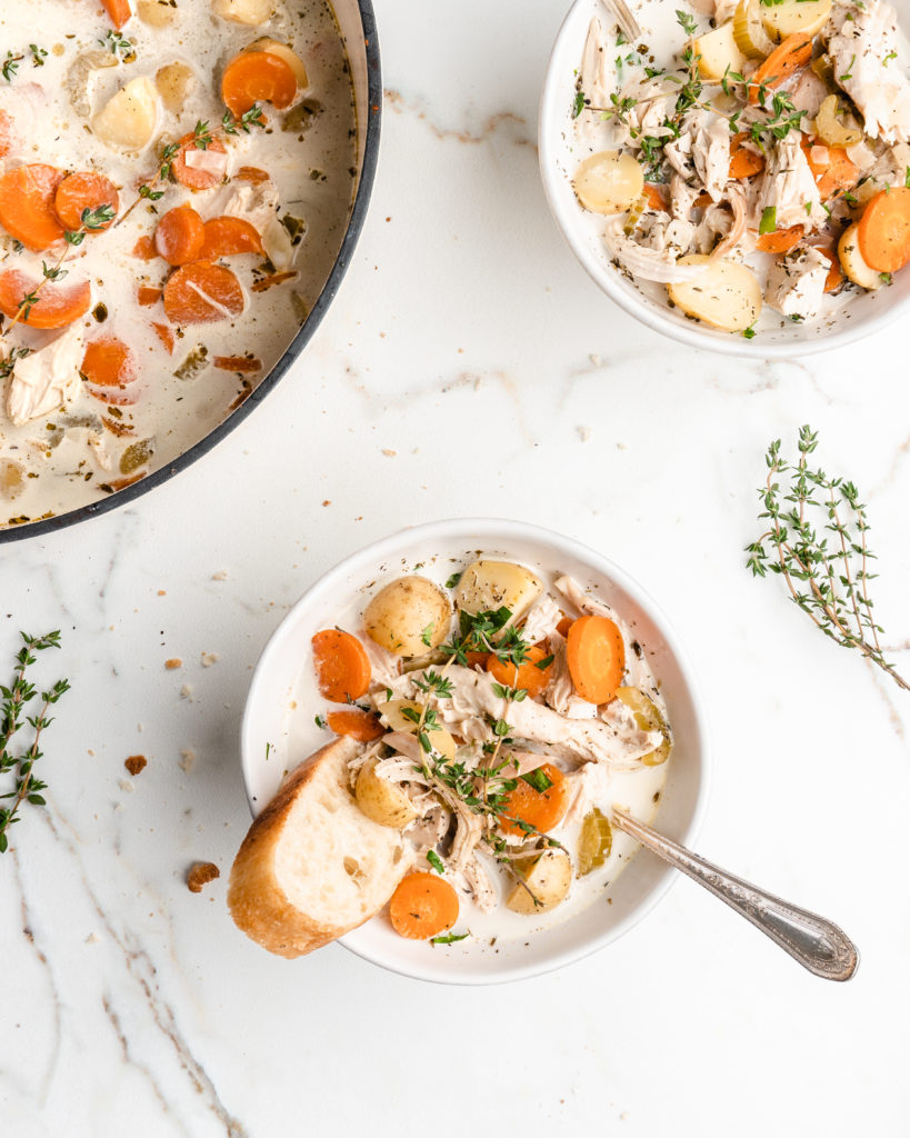 Creamy chicken soup is hot and ready to be eaten. Full of chicken, celery, carrots, potatoes, cream, bacon, and thyme, this soup is delicious!