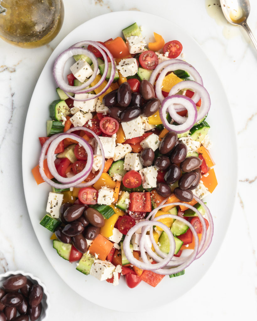 This easy greek salad features peppers, cucumbers, cherry tomatoes, Kalamata olives, feta cheese, red onions, and a homemade dressing 