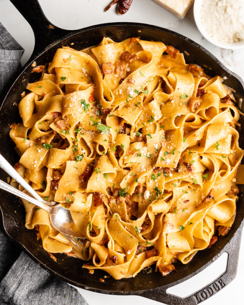 thick ribbons of pappardelle pasta are smothered in a spicy creamy stewed tomato sauce and topped with sharp parmesan cheese