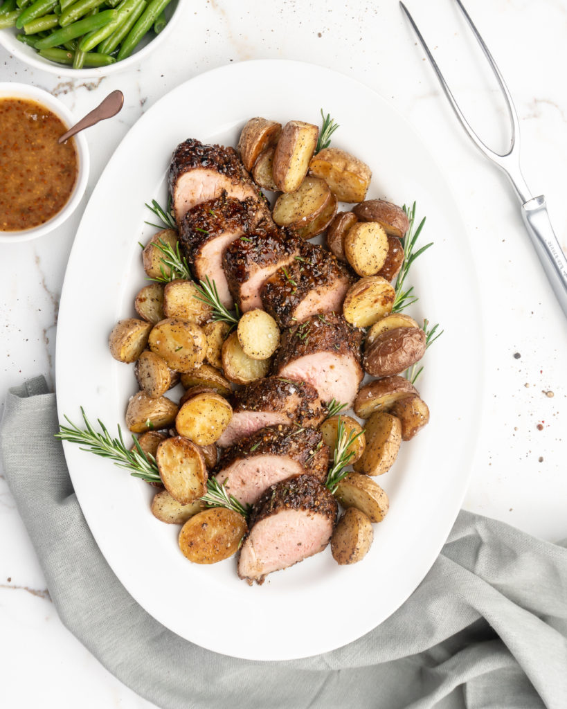 Pork tenderloin is crusted with peppercorns and then glazed with a rosemary peach mustard sauce.