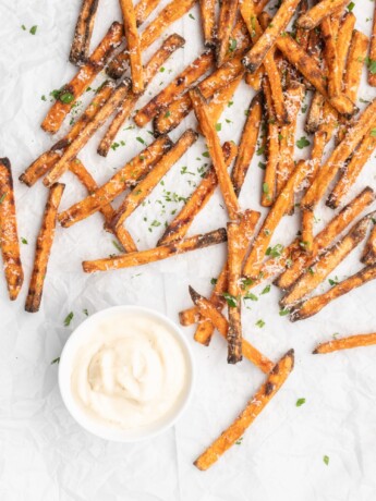 crispy oven baked yam fries are topped with finely shredded parmesan cheese and served with a flavorful homemade truffle lemon aioli