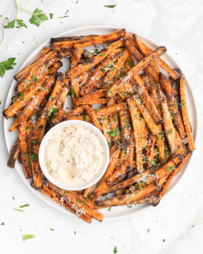 crispy oven baked yam fries are topped with finely  shredded parmesan cheese and served with a flavorful homemade truffle lemon aioli