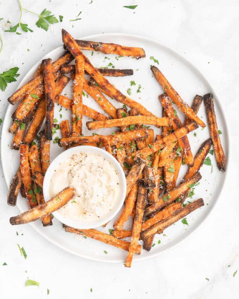 crispy oven baked yam fries are topped with finely shredded parmesan cheese and served with a flavorful homemade truffle lemon aioli