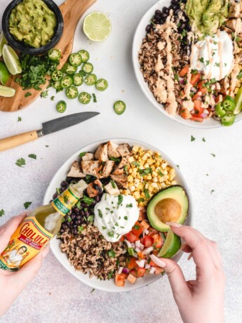 brown rice, grilled tequila lime chicken, corn, salsa, black beans, cilantro, avocado, and burrito sauce make up these amazing tequila lime grilled chicken burrito bowls