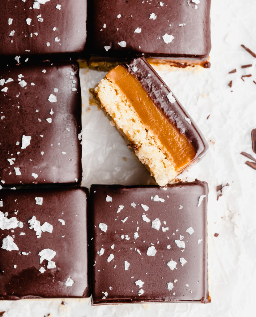 A buttery, rich shortbread layer is topped with a golden creamy caramel layer that is infused with vanilla beans an bourbon, which is further topped by a dark chocolate layer and flaky sea salt.