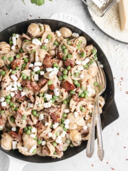 Pasta in a creamy parmesan wine sauce is paired with bits of goat cheese, peas, and crispy pancetta.