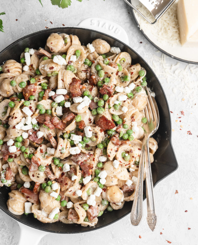 Pasta in a creamy parmesan wine sauce is paired with bits of goat cheese, peas, and crispy pancetta.