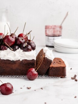 Rich chocolate loaf cake is swirled with cherry jam, then topped with fresh whipped cream and fresh cherries