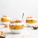 Layers of passion fruit and mango puree, yogurt, and coconut granola make up with tropical yogurt parfait