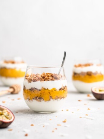 Layers of passion fruit and mango puree, yogurt, and coconut granola make up with tropical yogurt parfait