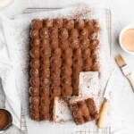 Espresso and vanilla infused sheet cake is brushed with a kahlua coffee simple syrup, and then topped with a creamy mascarpone whipped cream in this Tiramisu Sheet Cake