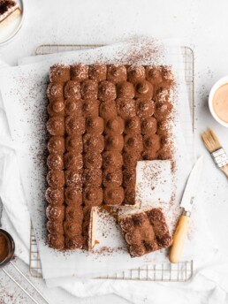 Espresso and vanilla infused sheet cake is brushed with a kahlua coffee simple syrup, and then topped with a creamy mascarpone whipped cream in this Tiramisu Sheet Cake