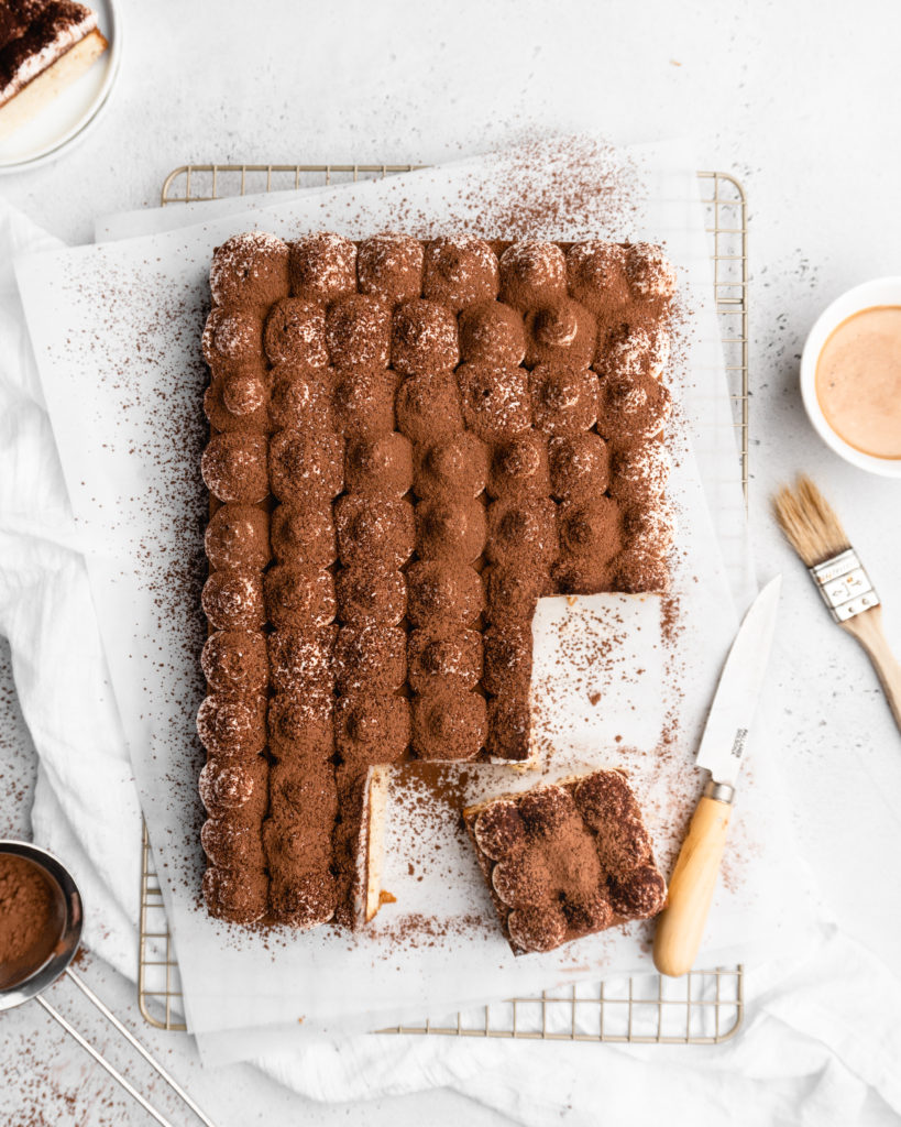 Espresso and vanilla infused sheet cake is brushed with a kahlua coffee simple syrup, and then topped with a creamy mascarpone whipped cream in this Tiramisu Sheet Cake