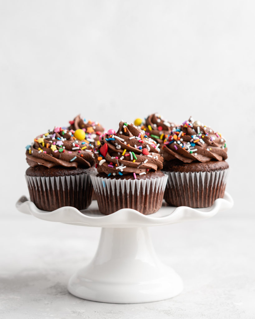 These Chocolate Cupcakes are moist and fluffy, and jam-packed with rich chocolate flavor! Topped with a rich, buttery chocolate buttercream