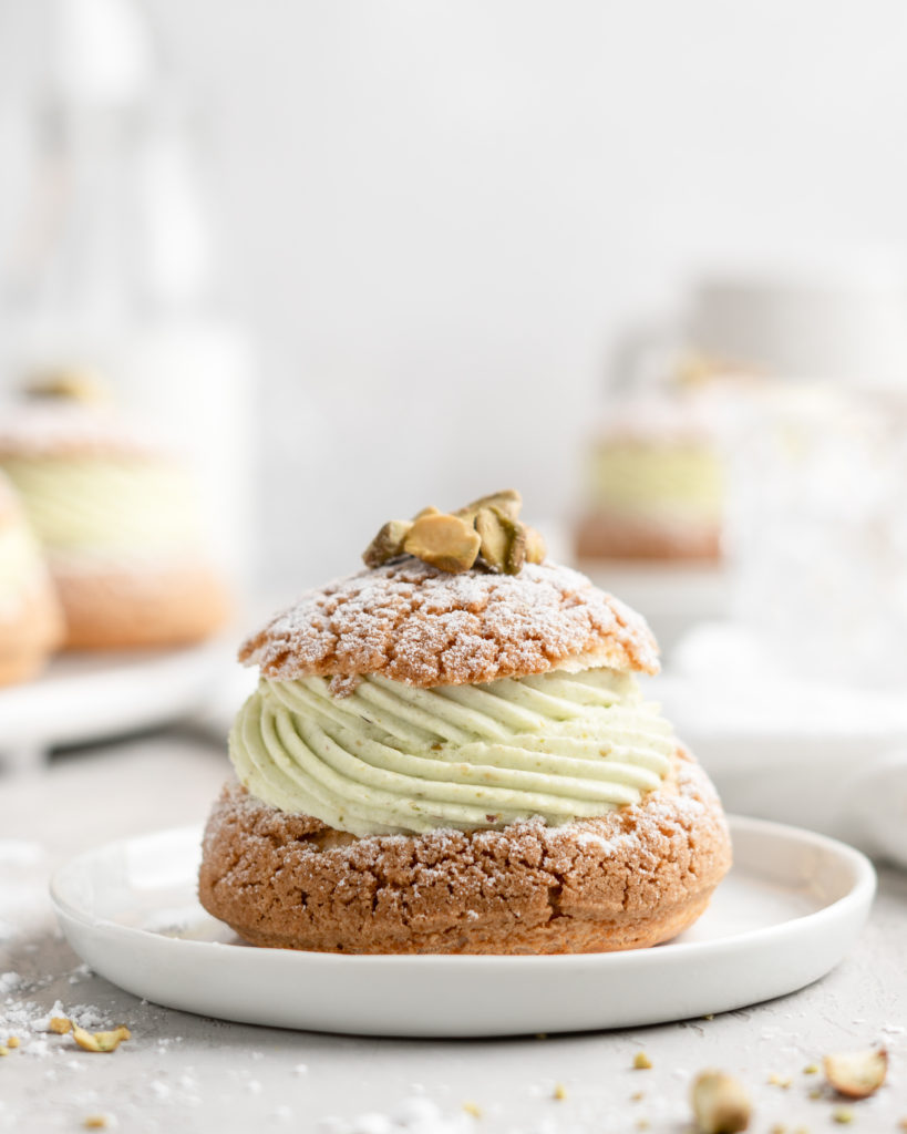 Cream Puff with craquelin topping, filled with a thick piped layer of whipped pistachio white chocolate ganache