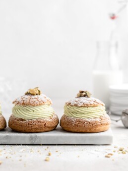 Cream Puff with craquelin topping, filled with a thick piped layer of whipped pistachio white chocolate ganache
