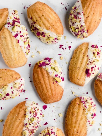 Pistachio madeleines made with rose water and dipped in white chocolate