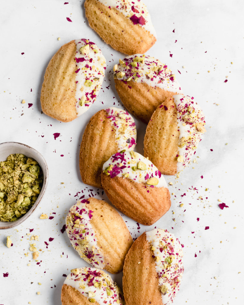 Pistachio madeleines made with rose water and dipped in white chocolate