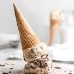 No churn almond ice cream is infused with a mocha swirl and full of chopped almonds, scooped into a cone