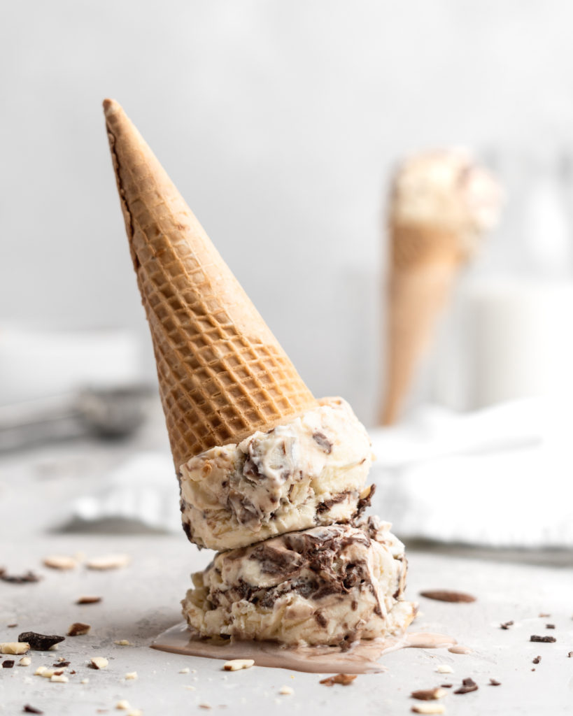 No churn almond ice cream is infused with a mocha swirl and full of chopped almonds, scooped into a cone