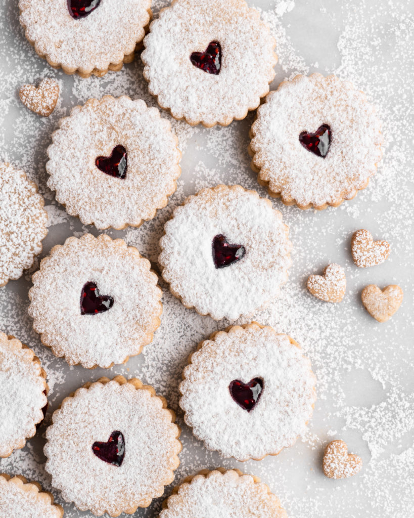 Linzer Cookies dusted with confectioners sugar and filled with raspberry jam