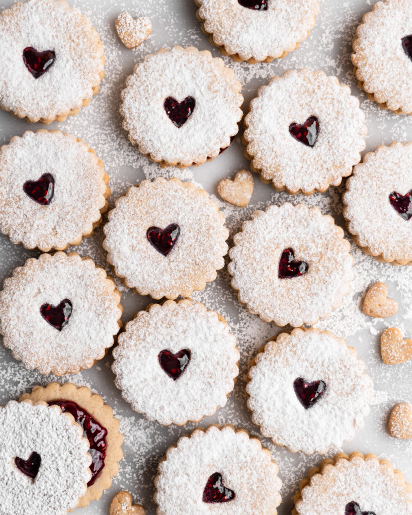 Linzer Cookies dusted with confectioners sugar and filled with raspberry jam