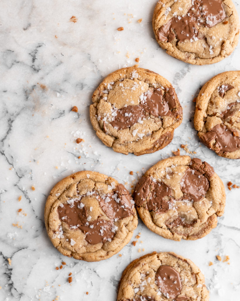 Chewy golden Toffee Milk Chocolate Chip Cookies on marble counter
