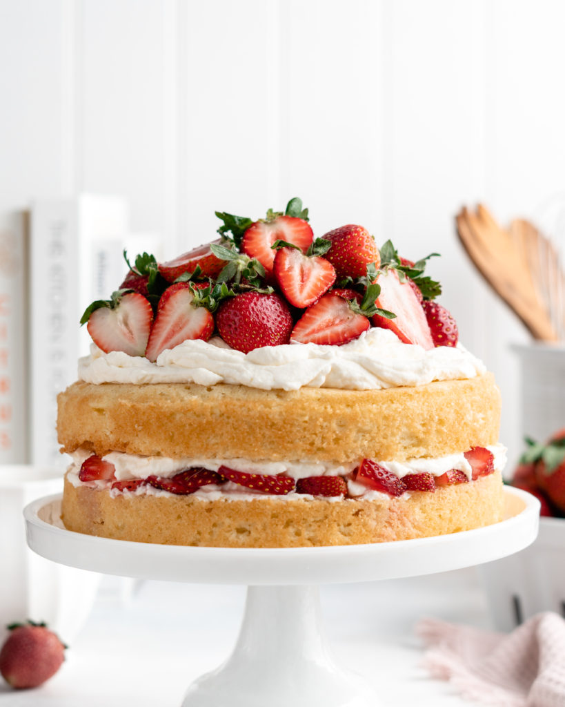 Light and fluffy sponge cake layers are sandwiched over a layer of mascarpone whipped cream and macerated strawberries in this Strawberry Shortcake Layer Cake