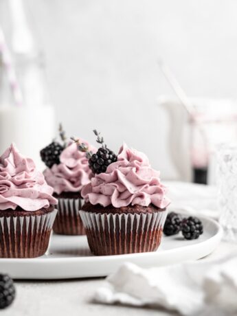 quick and easy chocolate cupcakes are topped with a creamy lavender blackberry buttercream frosting