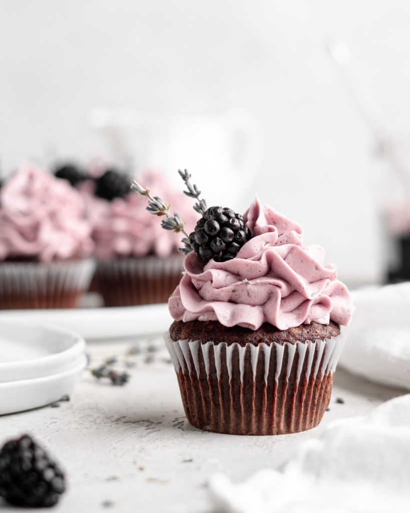 quick and easy chocolate cupcakes are topped with a creamy lavender blackberry buttercream frosting