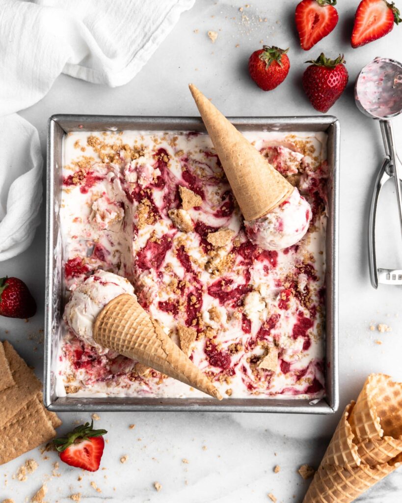 No Churn Strawberry Cheesecake Ice Cream in a square pan with cones
