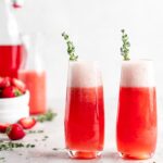 Bright red strawberry guava juice is mixed with sparkling rose wine in stemless champagne glasses to make Strawberry Guava Mimosa