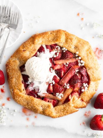 Flaky golden pie dough is folded into a galette shape over a strawberry rhubarb filling