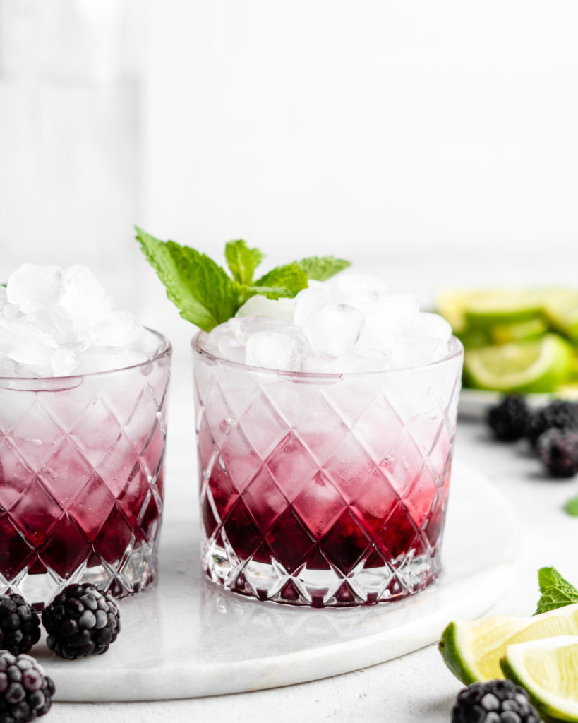 This blackberry rhubarb cocktail features a blackberry rhubarb syrup, soda water, vodka, mint, and lime