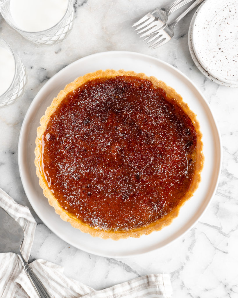 Velvety pumpkin tart is topped with a creme brulee topping and baked in a buttery shortbread crust