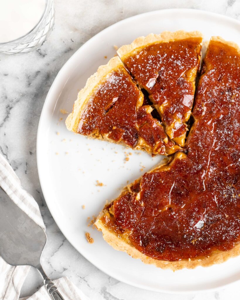 Velvety pumpkin tart is topped with a creme brulee topping and baked in a buttery shortbread crust