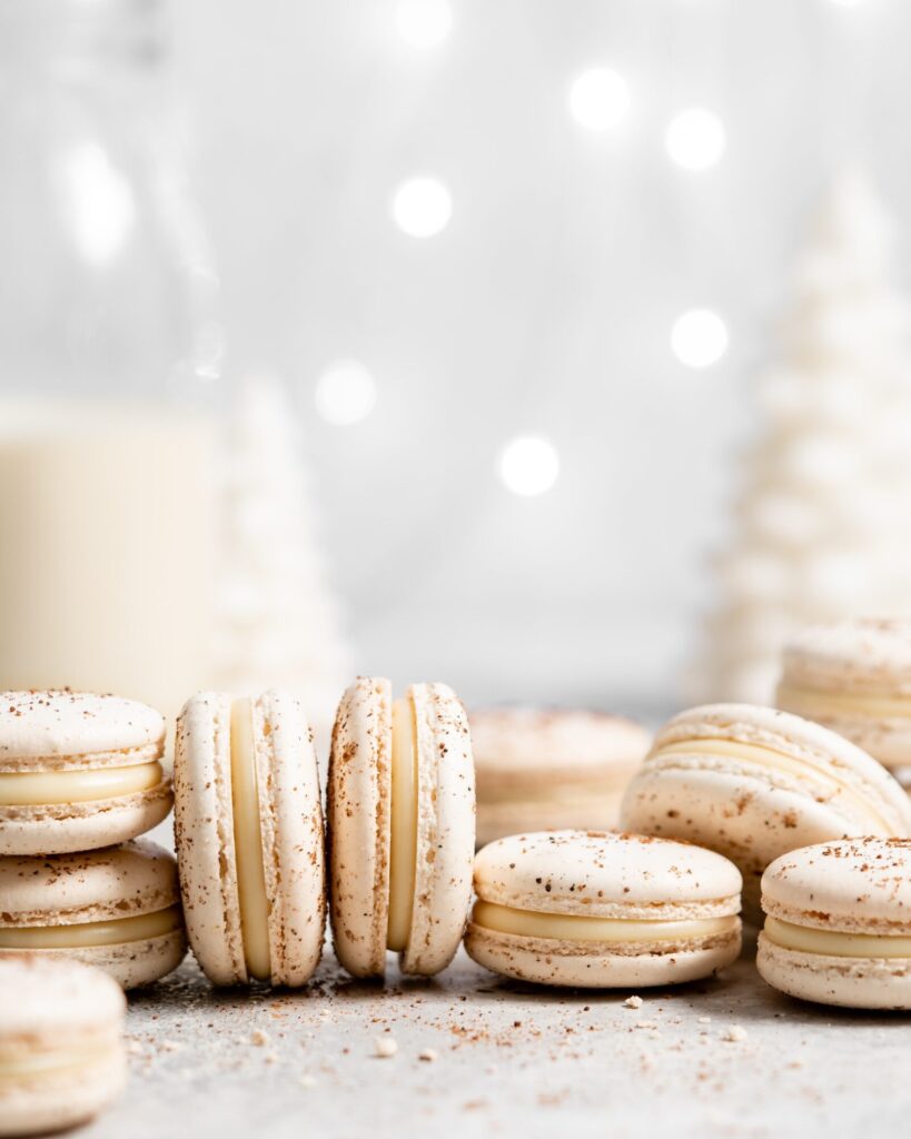 eggnog macarons filled with eggnog white chocolate ganache in a christmas scene