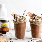 A thick chocolate s'mores milkshake with a toasted marshmallow topping, milk chocolate, and graham cracker