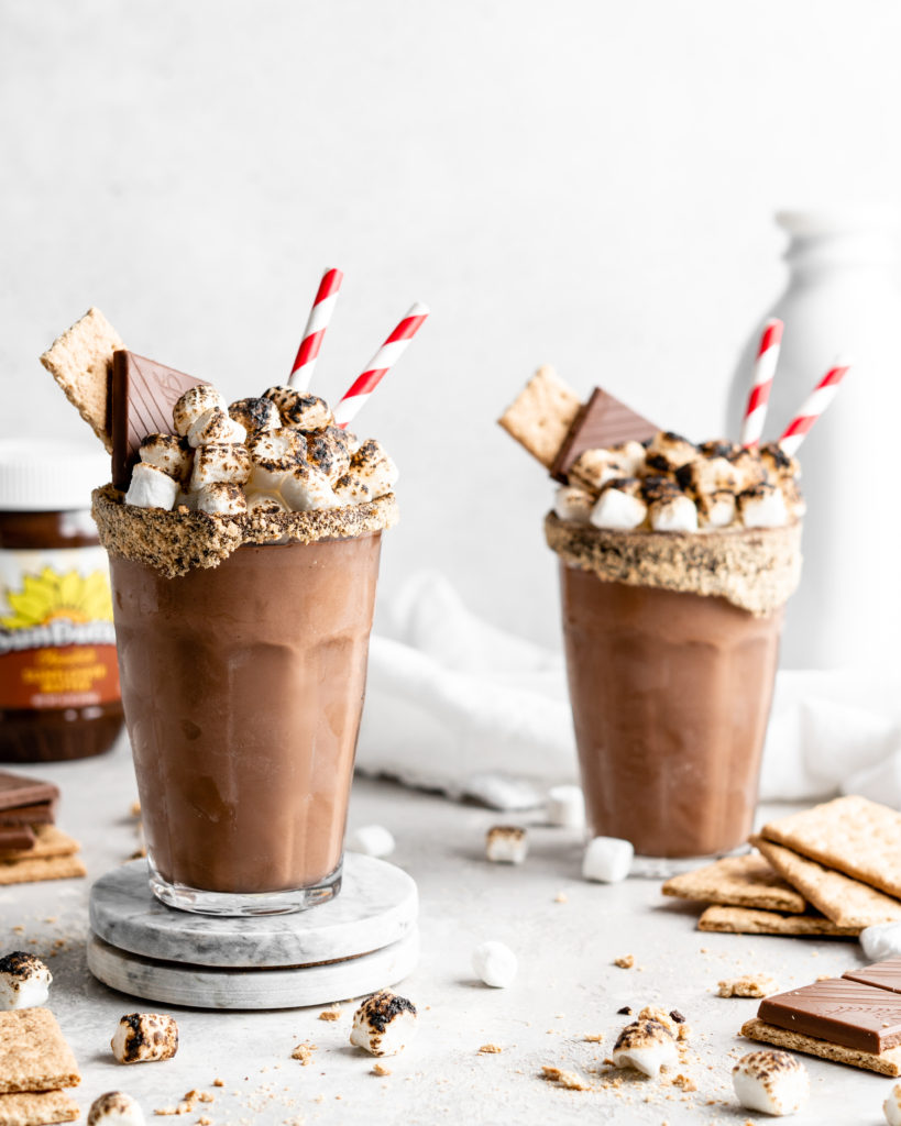 A thick chocolate s'mores milkshake with a toasted marshmallow topping, milk chocolate, and graham cracker