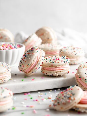 White Birthday Cake Macarons covered in rainbow sprinkles