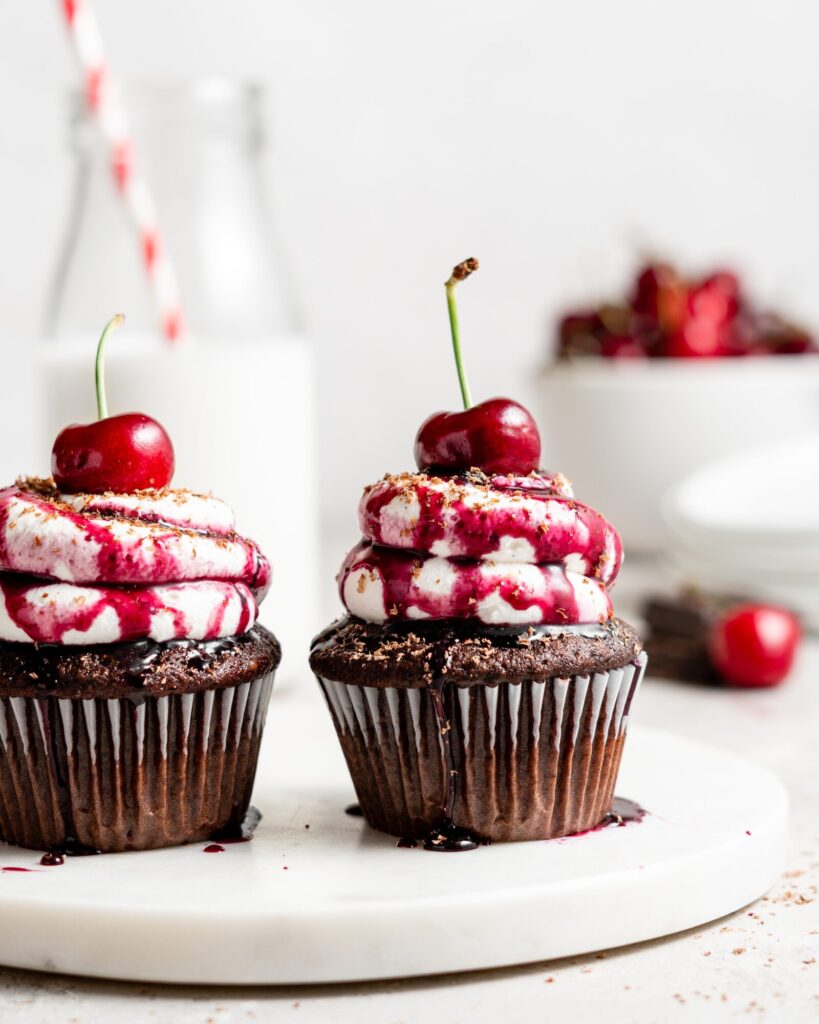 Black forest cupcake with cherry compote filling and whipped cream topping with cherry on top