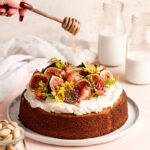 Single layer pistachio cake is topped with creamy honey buttercream and a ton of fresh fruit and flowers