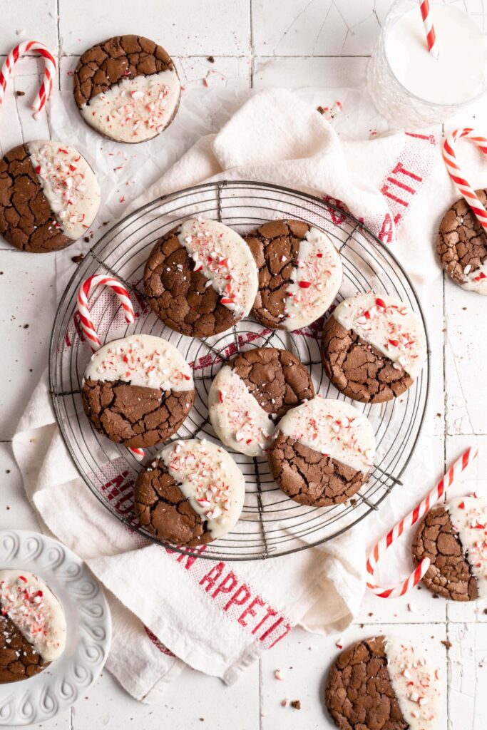 Crinkly fudgy chocolate peppermint brownie cookies dipped in white chocolate and sprinkled with crushed candy canes