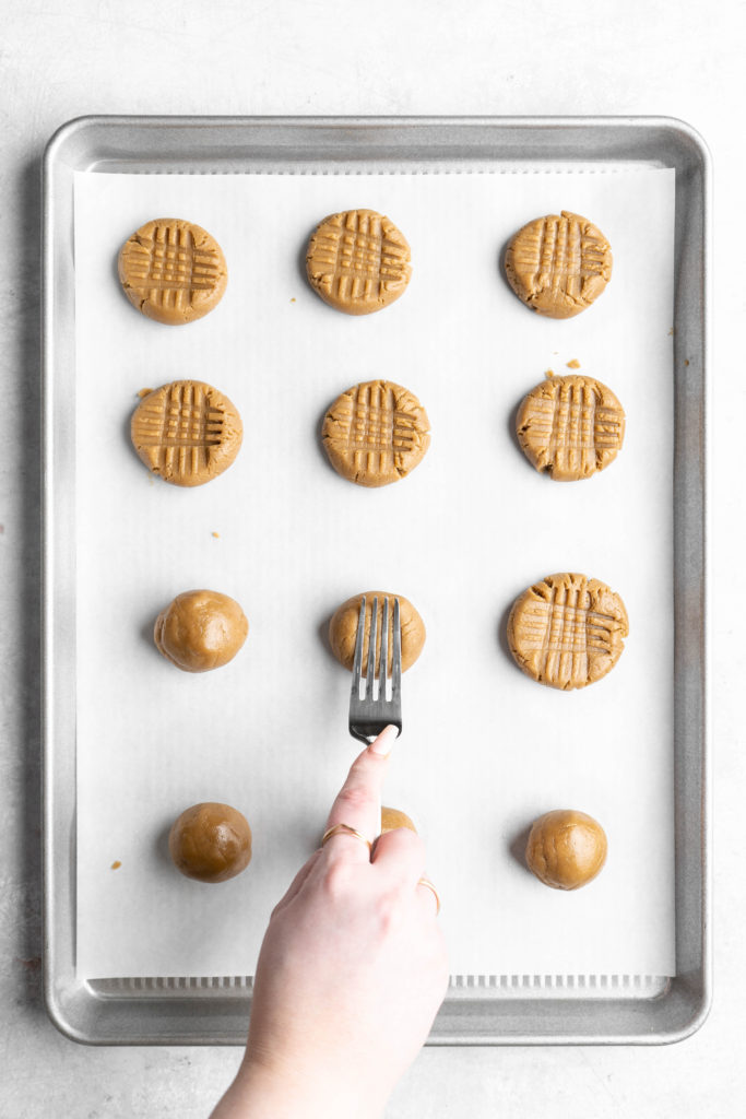 Pressing SunButter cookies into a criss-cross pattern with a fork